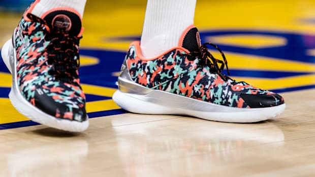 View of black, green, and orange Curry shoes.